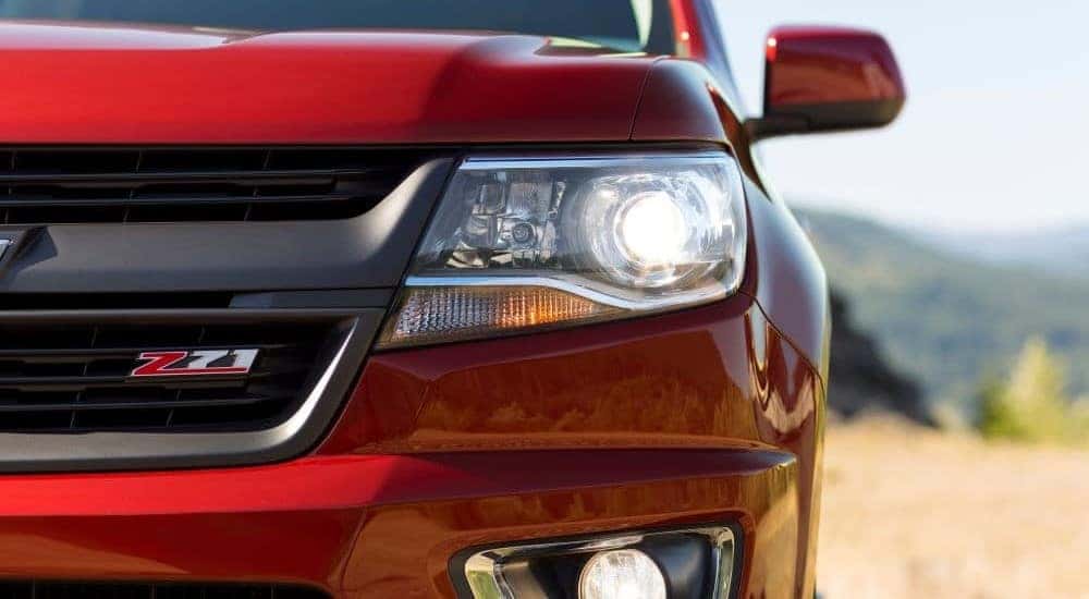 Close-up on the headlight of a red 2015 Chevy Colorado Z71.