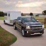 Black 2017 Chevy Silverado 1500 towing a trailer.