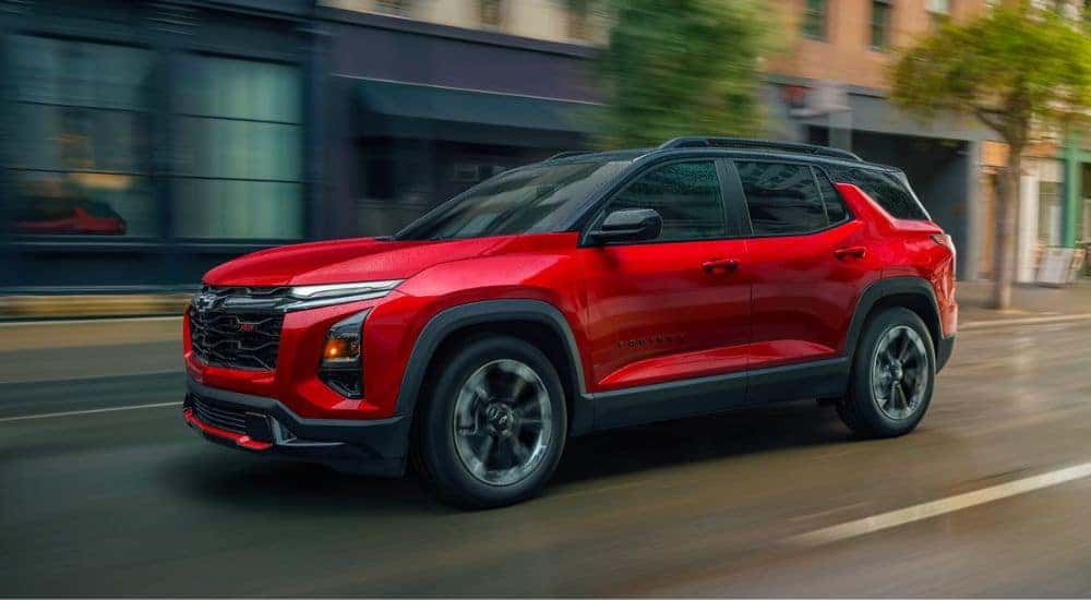 Red 2026 Chevy Equinox RS driving on a city street.
