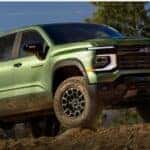 A green 2027 Chevy Silverado Trail Boss parked on rocky terrain.