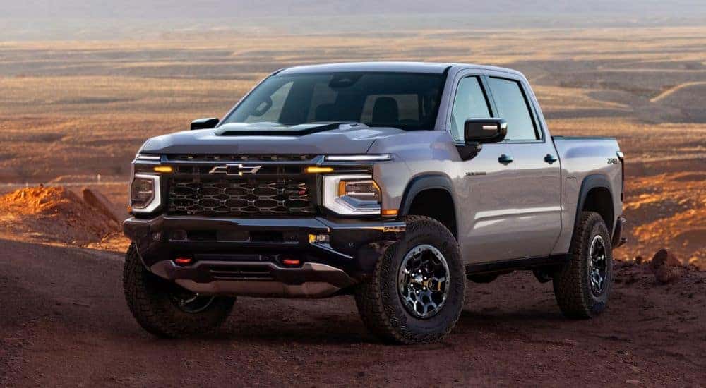 A silver 2027 Chevy Silverado 1500 parked in an open dirt field.