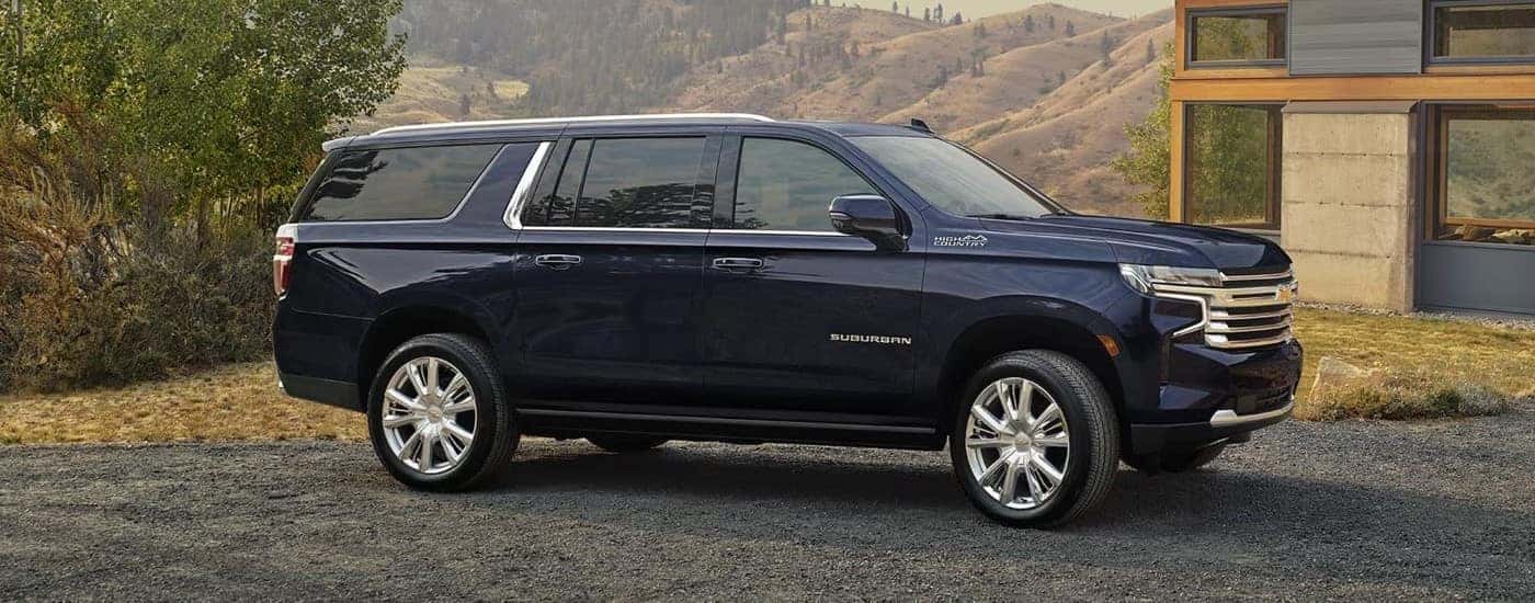 Blue 2024 Chevy Suburban High Country parked in a driveway.