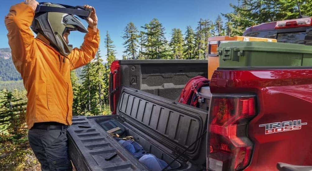 A person standing near the open tailgate on a 2026 Chevy Colorado Trail Boss.