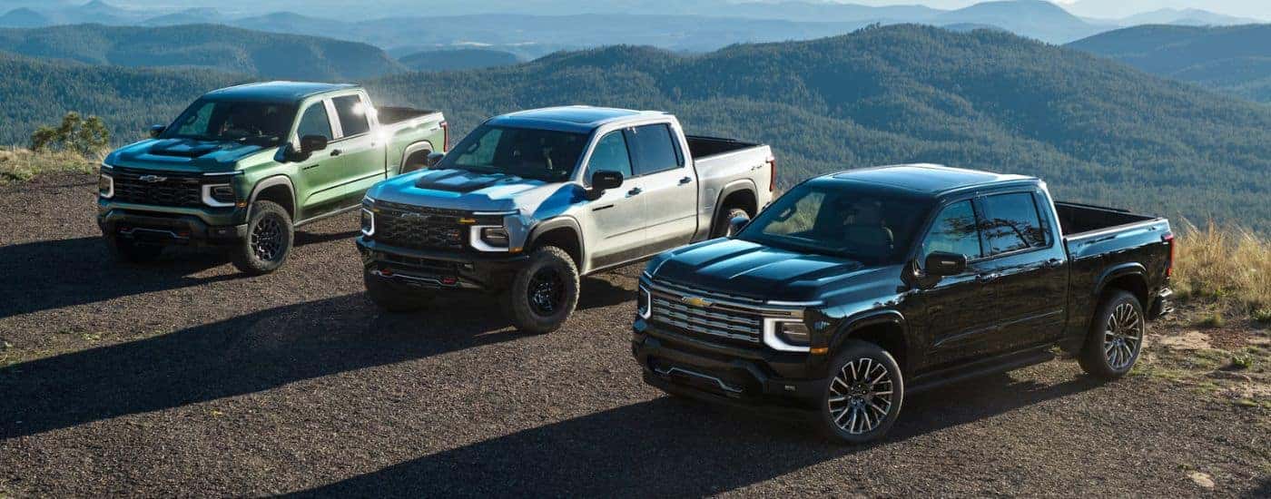 A trio of 2027 Chevy Silverado 1500s in Green White and Black.