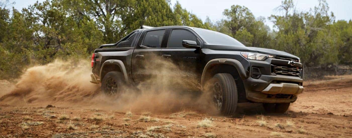 A black 2026 Chevy Colorado Trail Boss Midnight Edition kicking up dust.