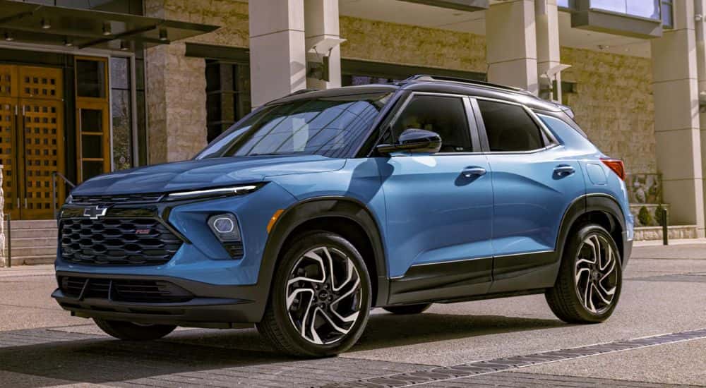A blue 2027 Chevy Trailblazer RS parked next to a building.