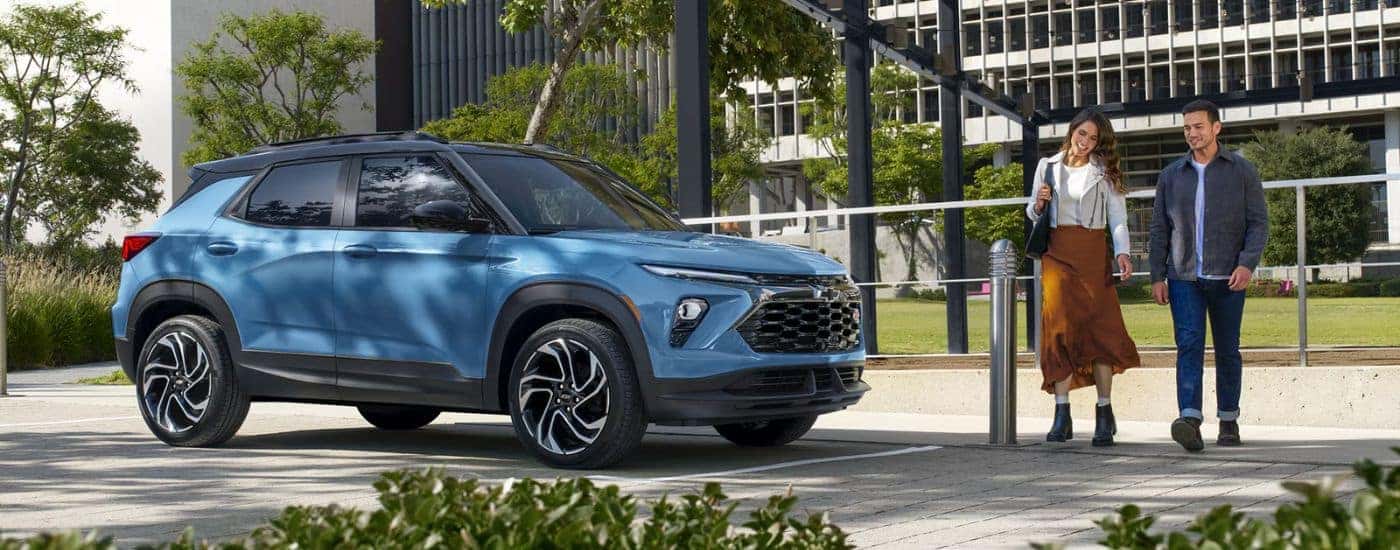 A blue 2027 Chevy Trailblazer parked by a couple.