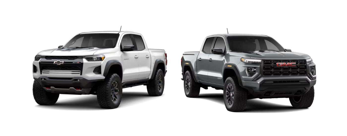 A white 2026 Chevy Colorado next to a gray 2026 GMC Canyon.