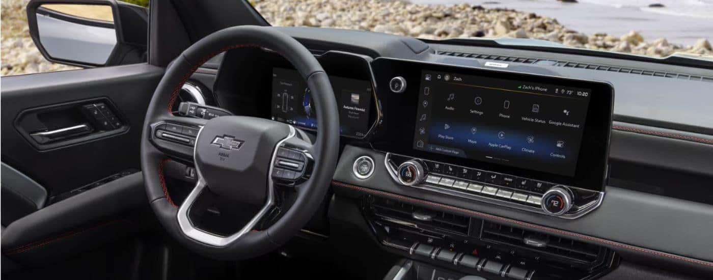 Black interior of a 2026 Chevy Colorado infotainment display and steering.