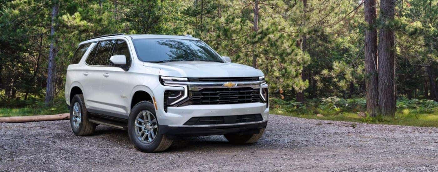 White 2025 Chevy Tahoe parked on a gravel driveway.
