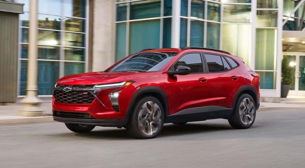 A red 2026 Chevy Trax RS driving in a city.