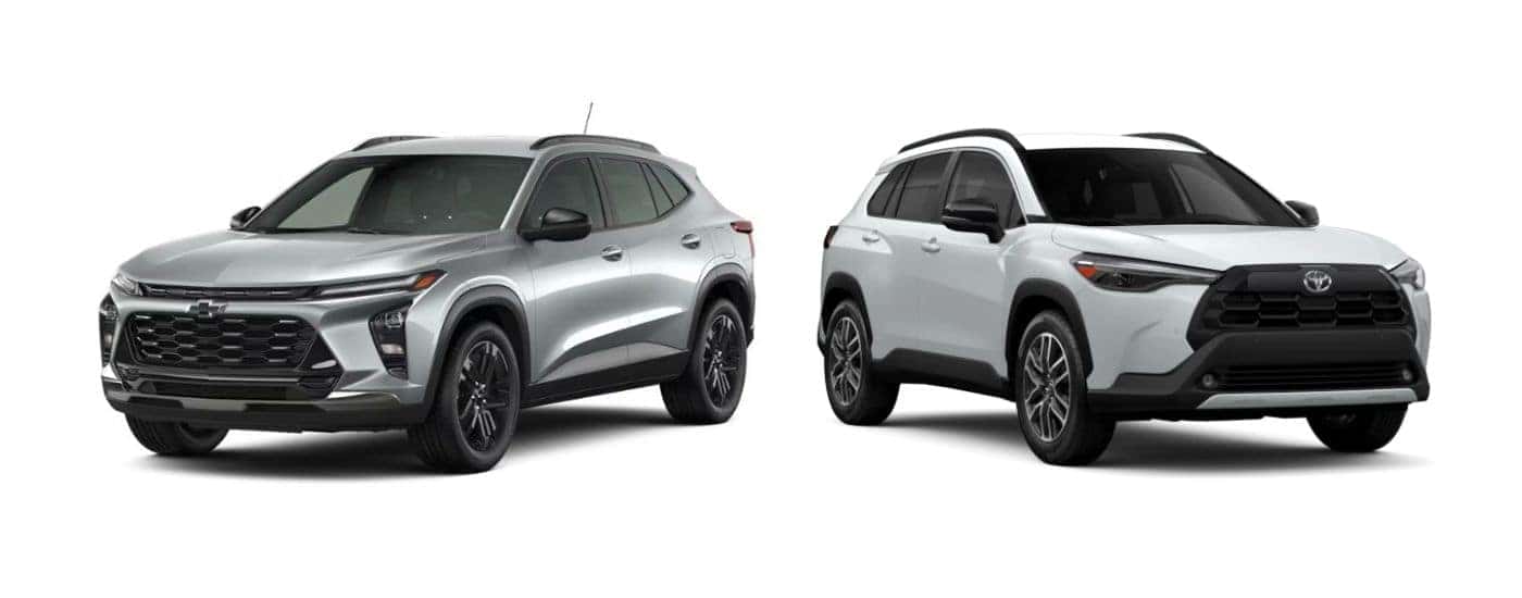 A silver 2026 Chevy Trax angled left and a white 2026 Toyota Corolla Cross angled right.