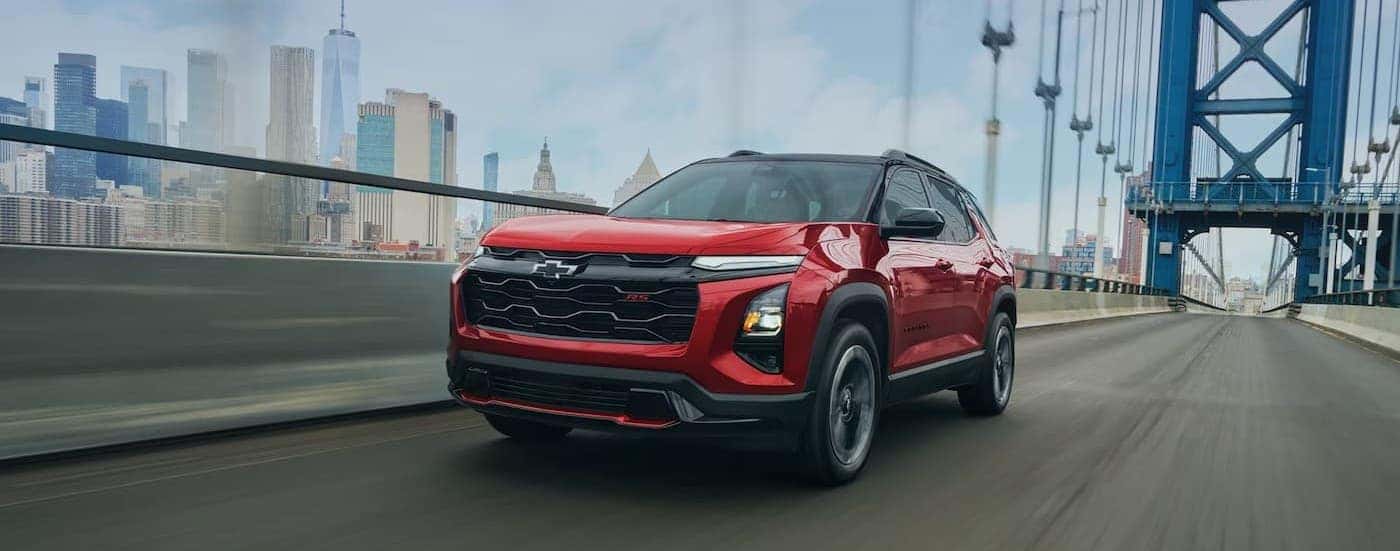 A red 2027 Chevy Equinox RS driving on a bridge.