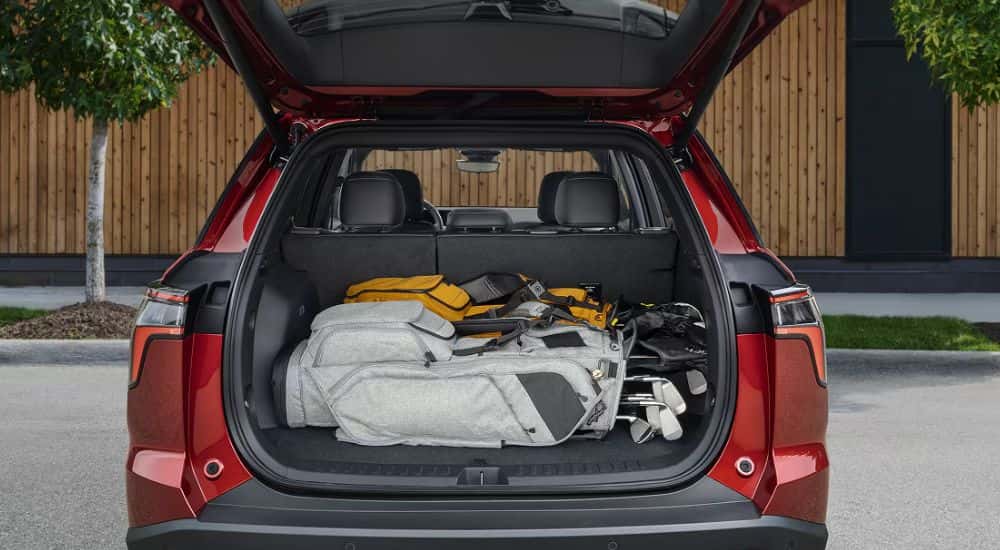 Rear gate open on a red 2027 Chevy Equinox.