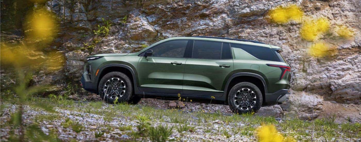 Green 2027 Chevy Traverse driving off-road.