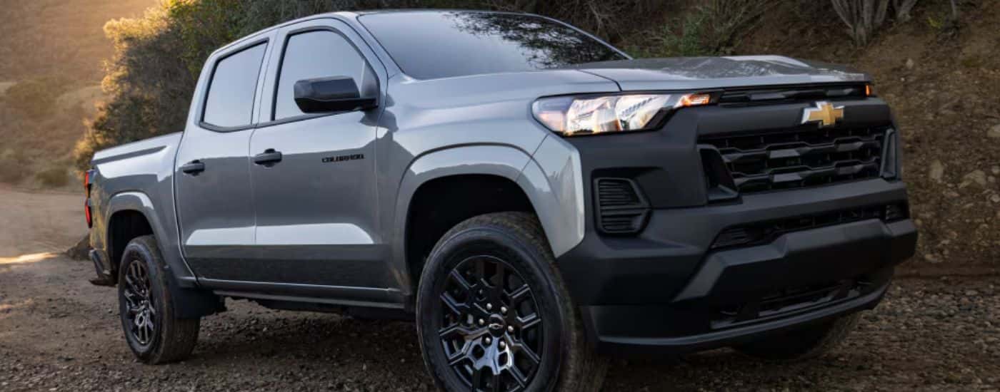 Side view of a grey 2027 Chevy Colorado driving off-road.