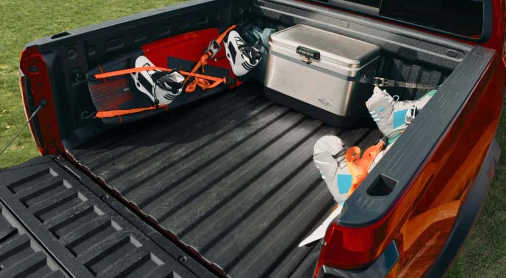 An open tail bed loaded with gear on a red 2027 Chevy Colorado.