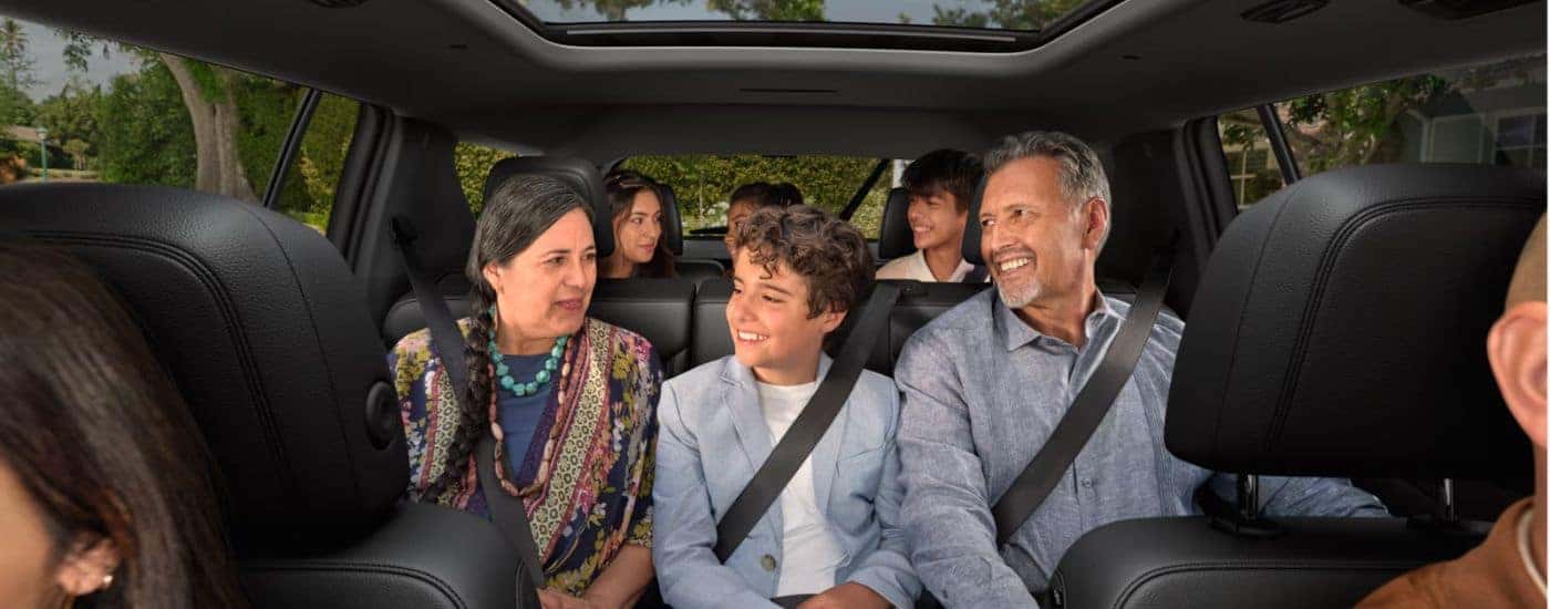 A family seated in the second and third rows of a 2027 Chevy Traverse.
