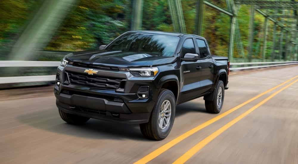A black 2023 Chevy Colorado driving on a bridge