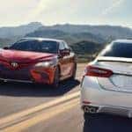 Two Toyota Camry Models passing each other on a highway