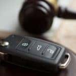 Car auction concept - gavel and car key on the wooden desk