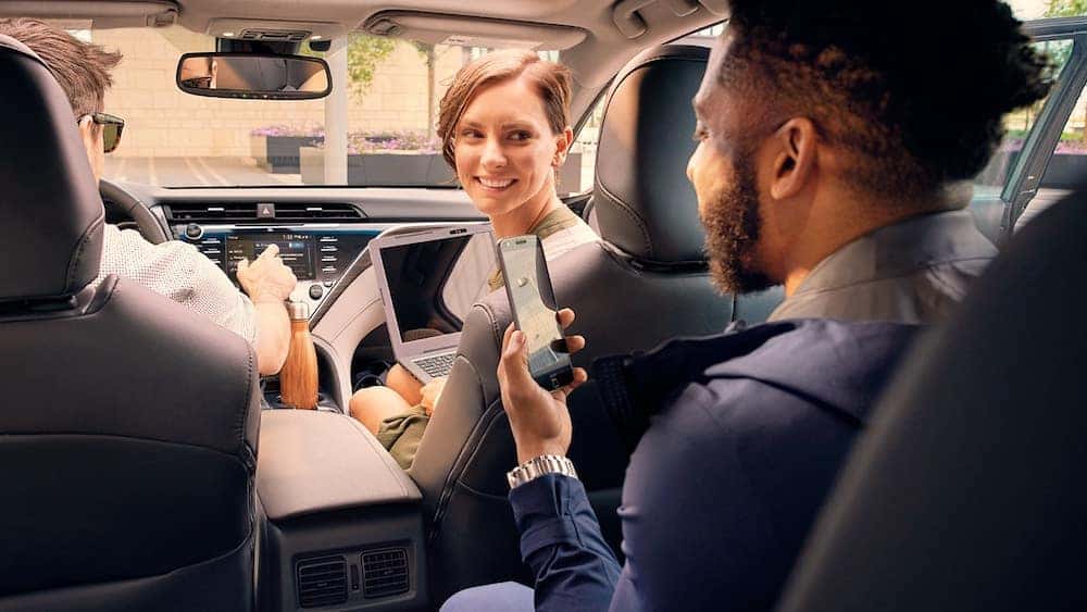 2019 Toyota Camry with man on smartphone using Toyota Remote Connect