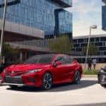 read and grey camry parked outside a building