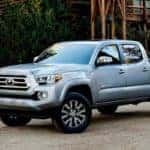 silver Toyota tacoma driving down the street