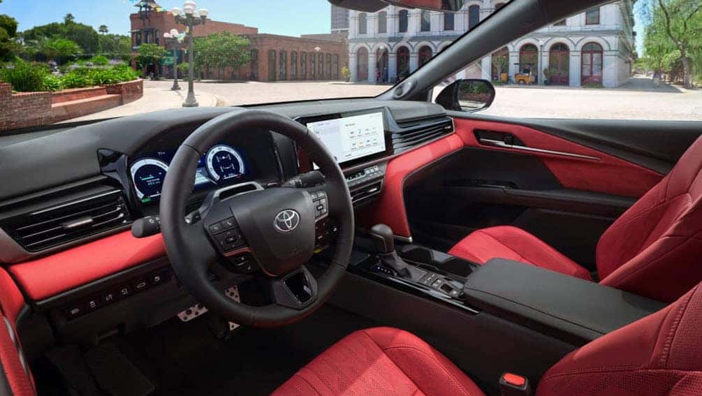 Interior of the 2025 Toyota Camry Hybrid featuring red leather seats and 12.3 inch multimedia display