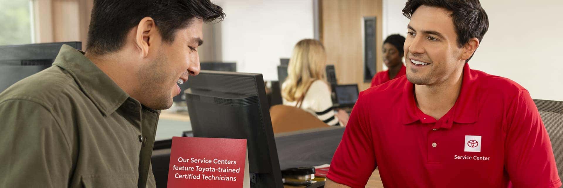 Toyota service advisor assisting customer at Earl Stewart Toyota Service Center in Lake Park FL before hurricane season