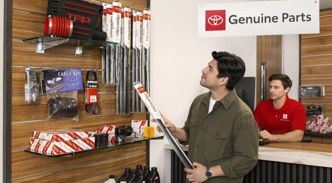 Customer browsing genuine Toyota parts including brake components at Earl Stewart Toyota parts counter in Lake Park, FL
