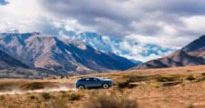 2024-Honda-Prologue-driving-opn-a-dirt-road-with-mountain-ranges-in-the-distance