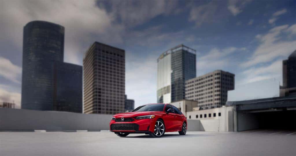 2025 Honda Civic Sedan Sport Touring Hybrid parked on a rooftop with skyscrapers beyond