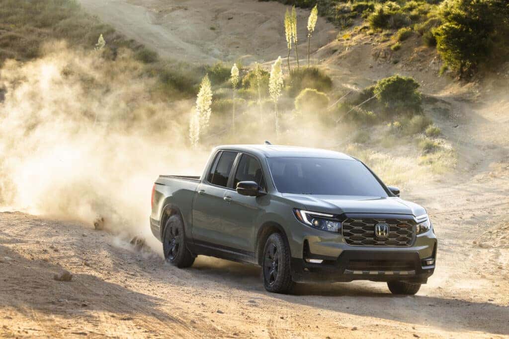 2026 Honda Ridgeline Trailsport driving down a sand hill with dirt kicking up behind the wheels