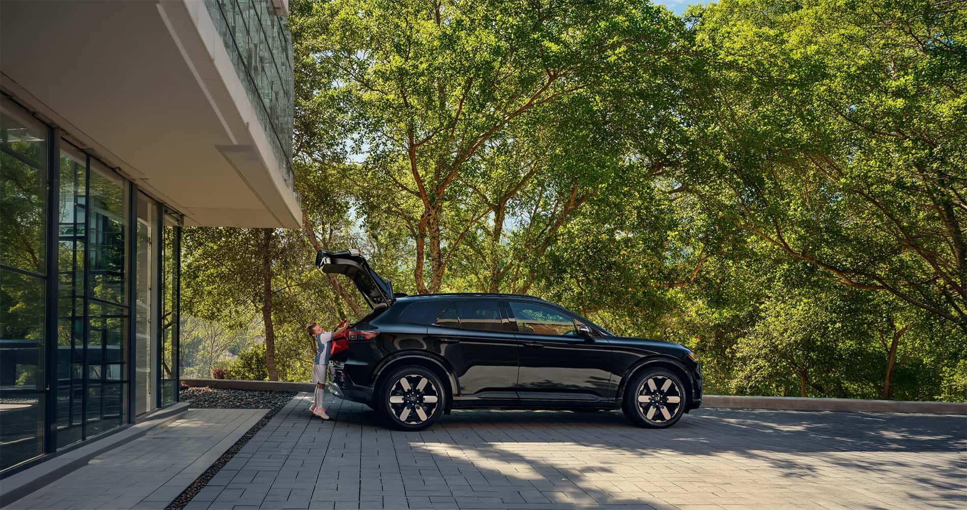 2026 Honda Prologue parked outside home with rear cargo area open and family loading gear