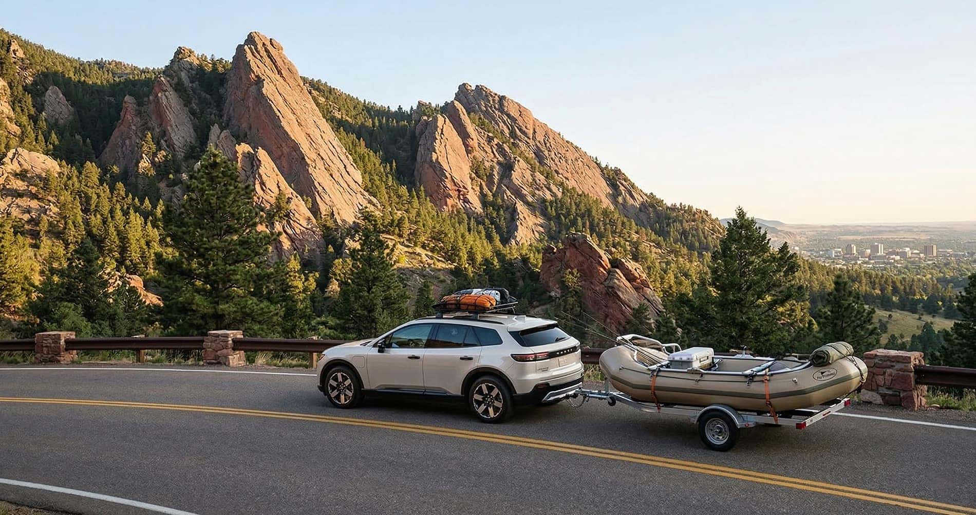 2026 Honda Prologue towing small boat on mountain road with scenic rock formations