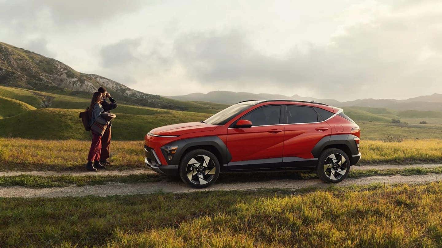 2026 Hyundai Kona parked on a scenic hillside trail with two people nearby, highlighting modern design and outdoor-ready versatility