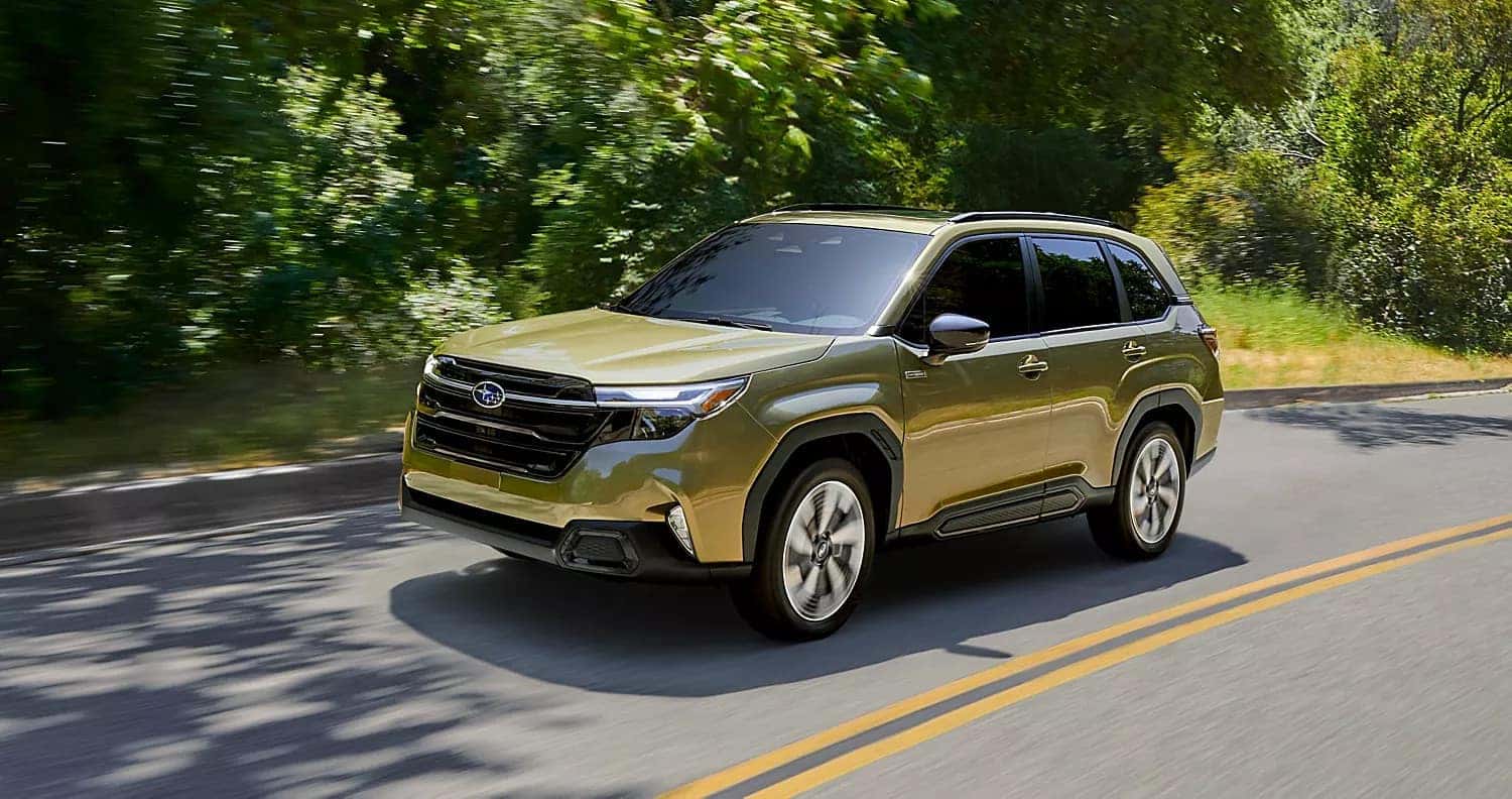 2026 Subaru Forester driving on a tree-lined road, highlighting smooth ride quality, visibility, and everyday practicality