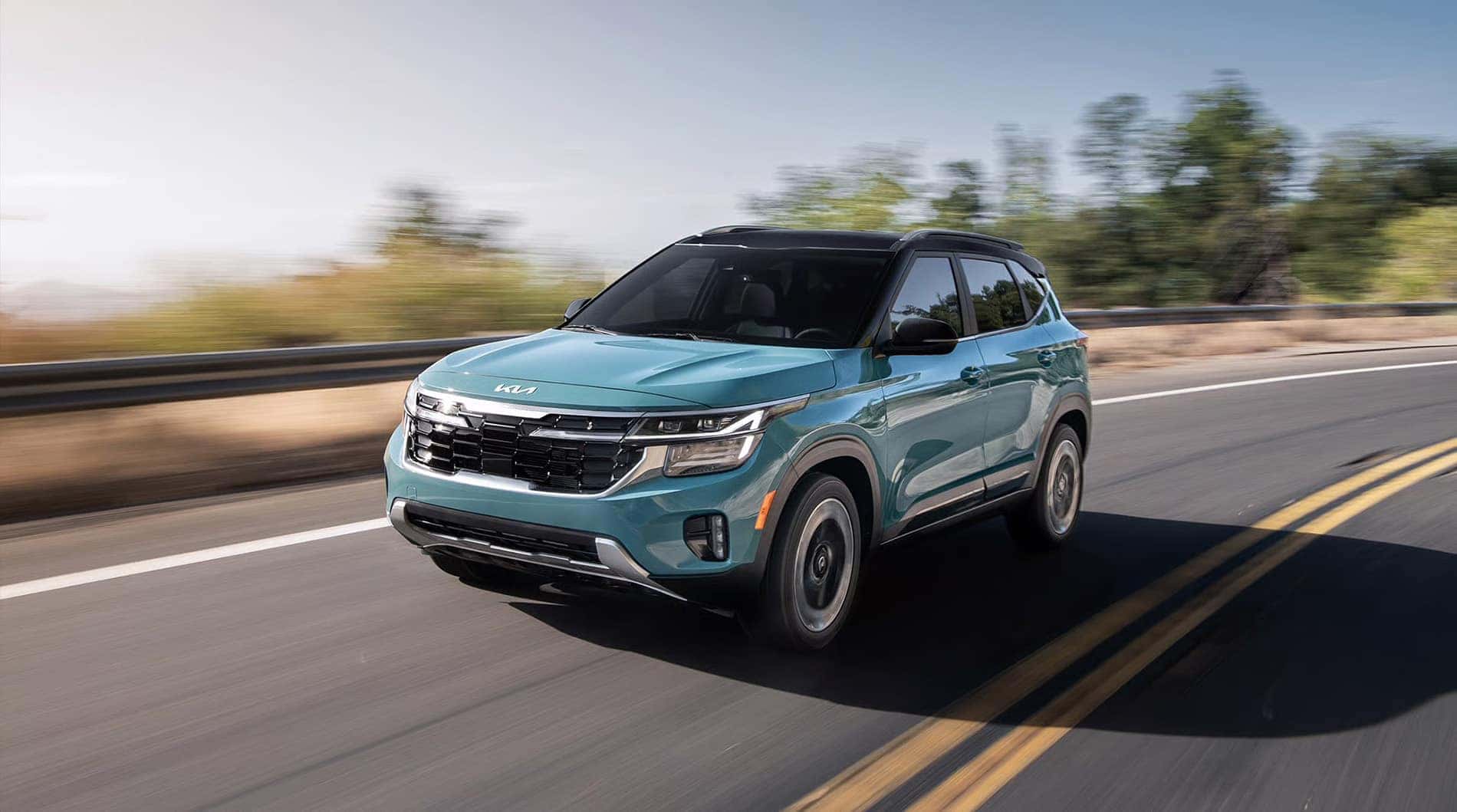 2026 Kia Seltos driving on an open road, highlighting smooth ride quality and compact SUV practicality