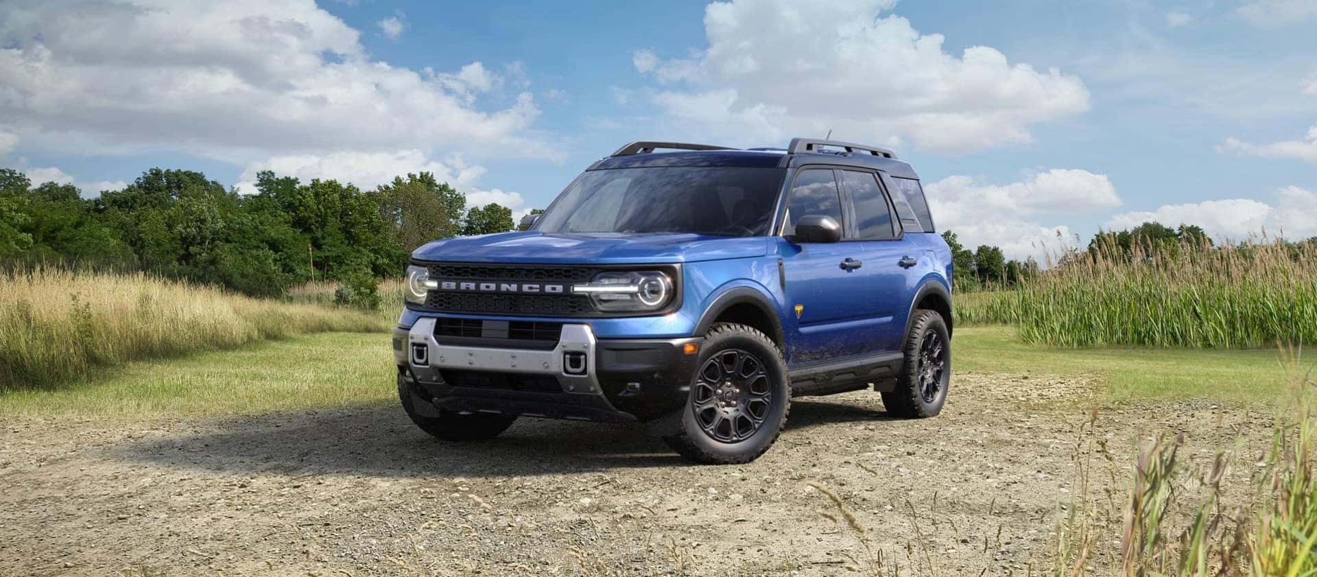 2026 Ford Bronco Sport parked on a dirt trail with rugged terrain, highlighting off-road capability and adventure-focused design
