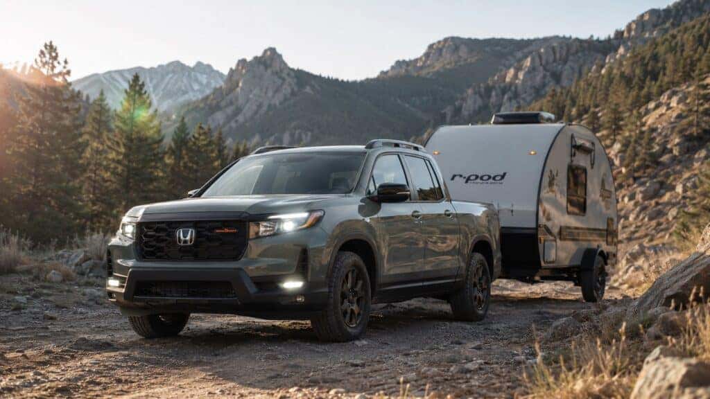 2026 Honda Ridgeline towing a Forest River R-Pod 194 camper through the mountains at sunrise