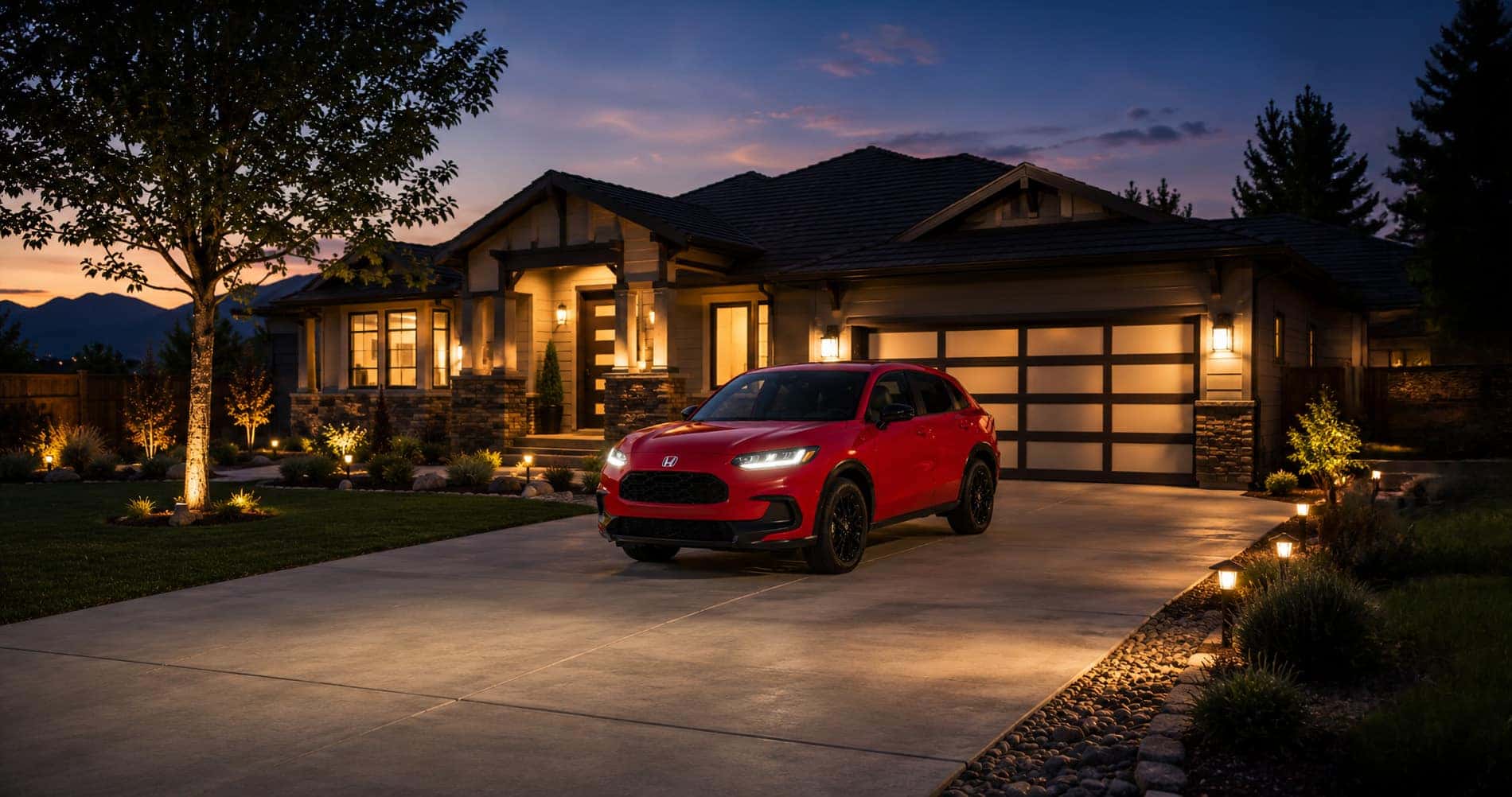 Red 2027 Honda HR‑V Sport trim level parked in a well‑lit suburban driveway at dusk, emphasizing sleek design and family appeal.
