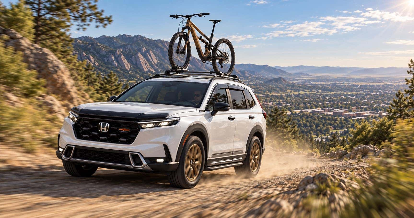2027 Honda CR-V TrailSport driving near Boulder, CO with a mountain bike on the roof