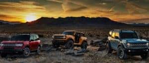 Three Ford 2020 Broncos on desert landscape at sunset