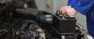 Technician replacing a car battery