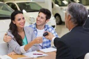 Couple Smiling handing keys 1400