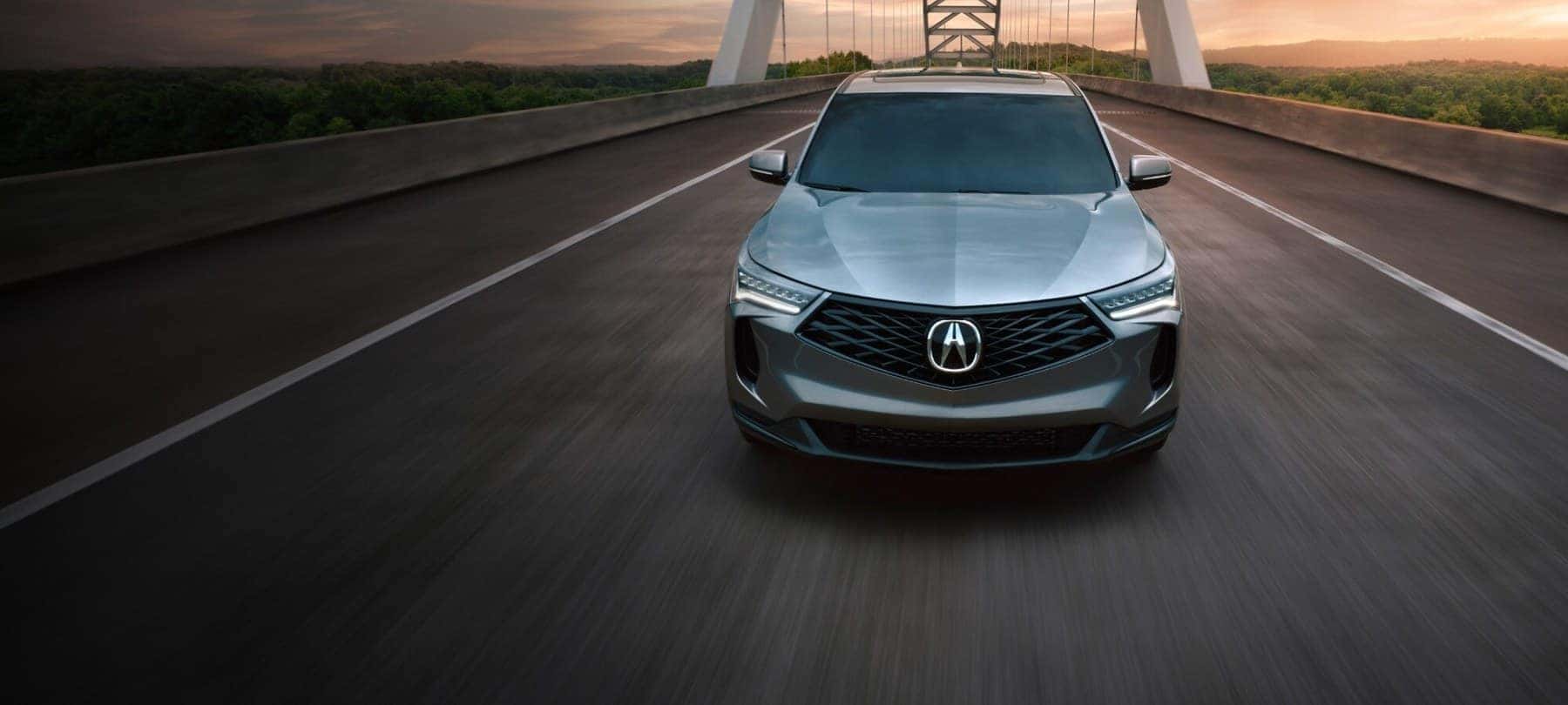 2026 Acura RDX compact luxury crossover, front view on a bridge at dusk