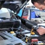 mechanic pouring clean engine oil into vehicle