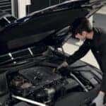 A Genesis technician performing a service inspection under the hood of a Genesis vehicle at Genesis of North Cincinnati.