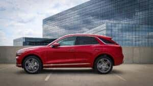 2026 Genesis Electrified GV70 parked in front of modern architecture in Schaumburg, IL, showcasing its sleek design and luxury all-electric performance.